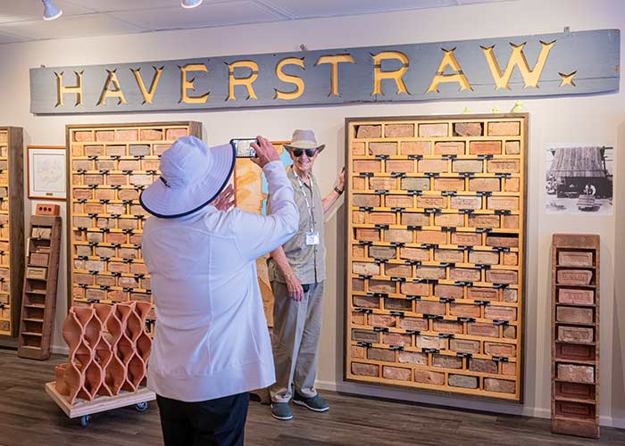Two people in hats explore the brick museum port excursion in Haverstraw, with one taking a photo.