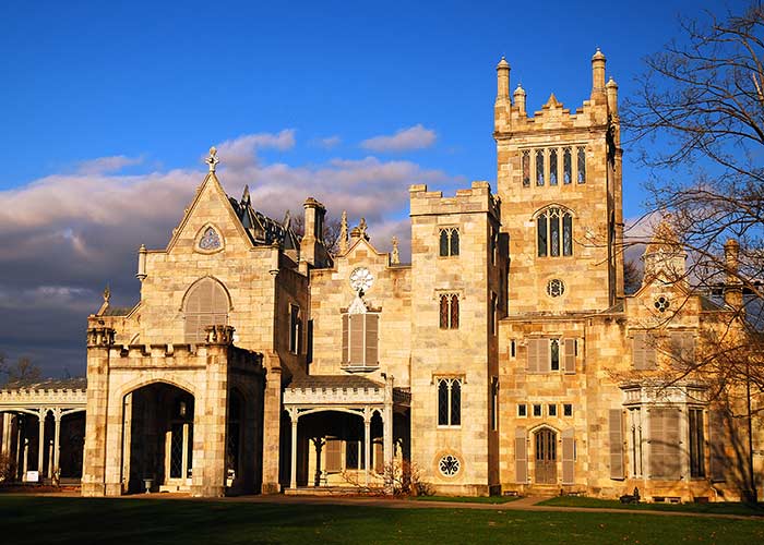 Historic Lyndhurst Mansion in the Sleepy Hollow port stop, with Gothic architecture, featuring towers and arched windows, set against a blue sky.