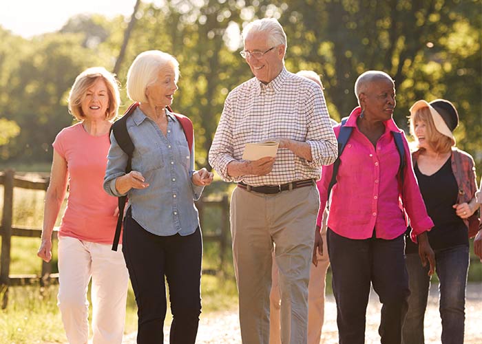 A group of cruise guests walking through the gardens at Patti’s 1880s Settlement in Paducah exploring historic shops and scenic grounds.