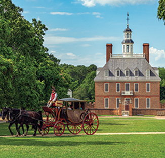 Dual horses pulling a carriage in front of Colonial Williamsburg