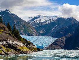 Scenic view of snow-capped mountains, glacier and ocean in Alaska during a national parks cruise excursion.
