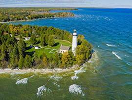 Aerial view of the Cana Island Lighthouse on a forested peninsula in Bailey's Harbor, WI, on Lake Michigan.
