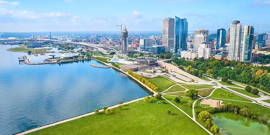 Aerial view of the Milwaukee cruise port and skyline along Lake Michigan, with green parks and pathways along the waterfront.