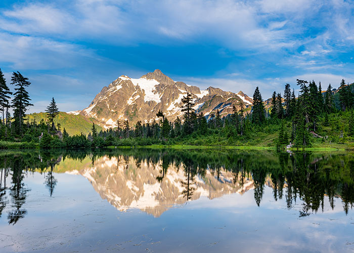 Remote alpine lake and snow-dusted peaks in North Cascades National Park explored through a guided cruise and land excursion experience