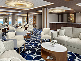 The River Lounge, a common area on American Anthem with several small tables with grey and red armchairs surrounding them on red and white patterned carpet. Along the center part of the back wall, there is a grand piano. There are also floor-to-ceiling windows on the left wall with views of the Columbia River.