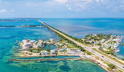 A long stretch of highway surrounded by the bright blue ocean in Key West