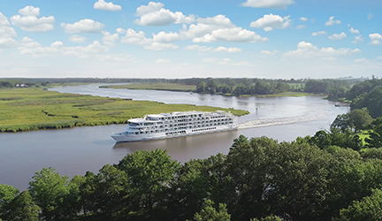An American Cruise Lines American Riverboat small cruise ship sailing along the winding Mississippi River.