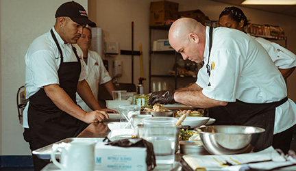 American Cruise Lines kitchen staff preparing a delicious meal onboard.