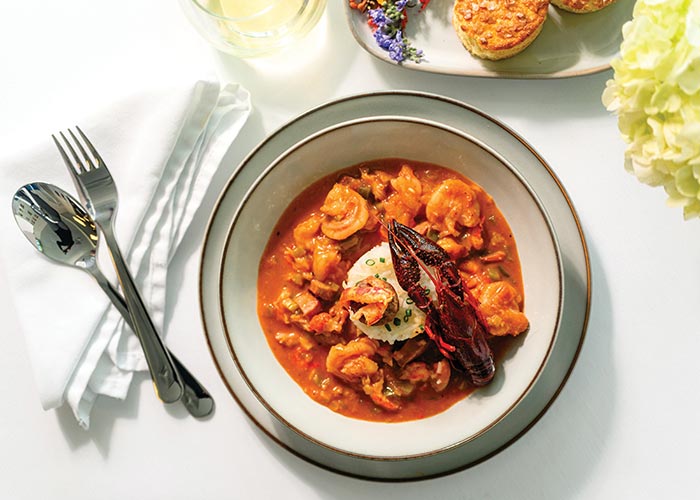 A plate of Crawfish Etouffee, Louisiana Crawfish & Smoked Sausage Etouffee, Green Peppers, Tomato, and Creole Spices with rice in the middle, served aboard American Cruise Lines.
