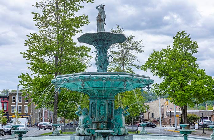 The decorative, green Broadway Fountain with sculptures in a park setting during American Cruise Lines' port stop in Madison, IN.